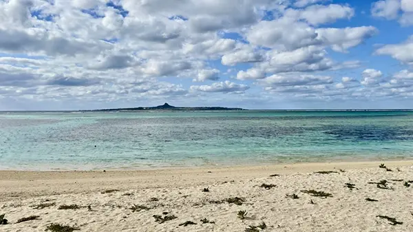 저 멀리 이에섬의 산이 보이는 비세 해변의 투명한 물결