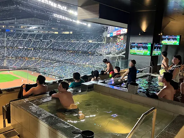 사우나 내부 통유리를 통해 경기장을 직관하며 휴식을 취하는 모습