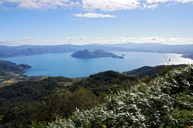 탁 트인 시야를 자랑하는 도야호의 푸른 물결과 주변 산맥의 전경