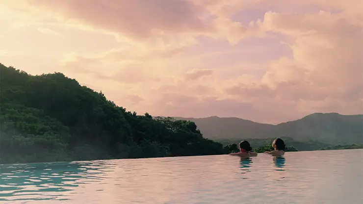 석양 질 무렵 숲을 내려다보는 스파 정글리아의 인피니티 풀