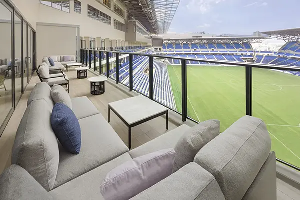 호텔 로비 통유리창 너머로 펼쳐지는 피스 스타디움의 광활한 뷰