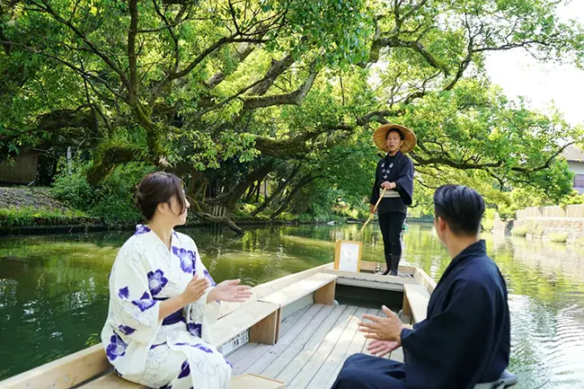 야나가와 수로를 따라 노래를 부르며 뱃놀이를 이끄는 사공의 모습