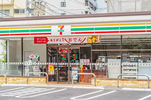 세븐일레븐 매장 내에 위치한 세븐은행 ATM에서 현금을 인출하는 여행자의 모습