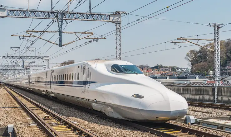 하카타역 승강장에 서 있는 매끈하고 날카로운 디자인의 최신 신칸센 열차